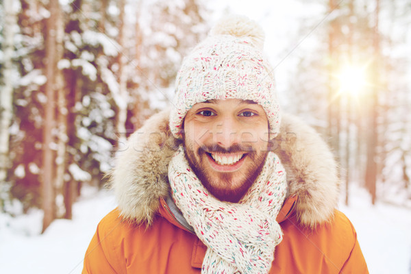 smiling young man in snowy winter forest Stock photo © dolgachov