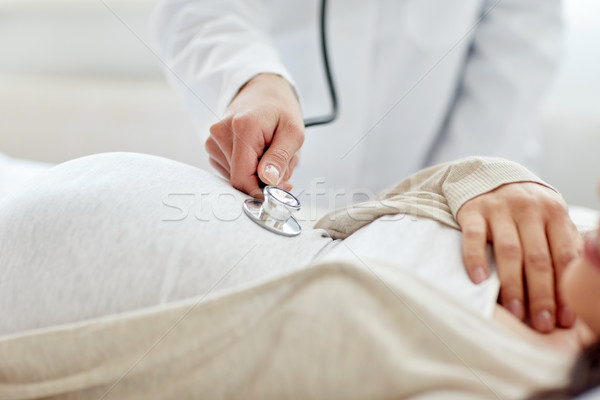 doctor with stethoscope and pregnant woman Stock photo © dolgachov