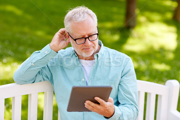 senior man with tablet pc at summer park Stock photo © dolgachov