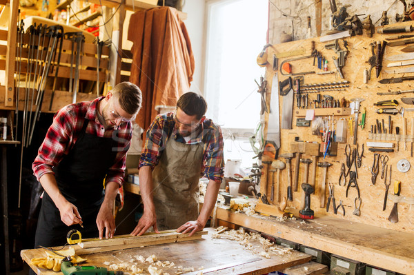 carpenters with ruler and wood plank at workshop Stock photo © dolgachov