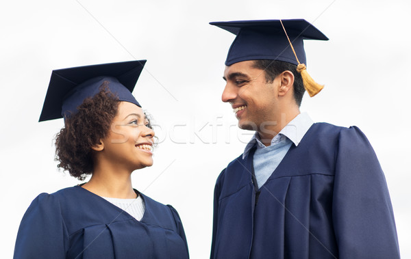 Stock photo: happy students or bachelors in mortar boards