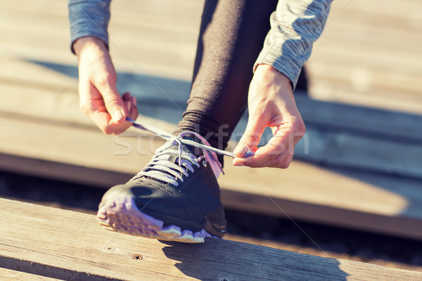 close up of sporty woman tying shoelaces outdoors Stock photo © dolgachov