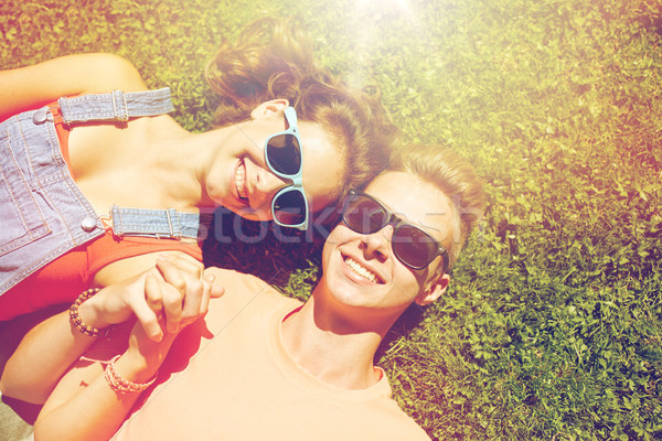 happy teenage couple lying on grass at summer Stock photo © dolgachov