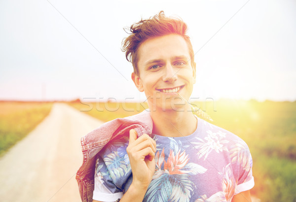 smiling young hippie man on country road Stock photo © dolgachov