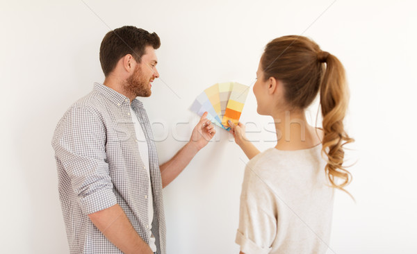 happy couple with color samples at new home Stock photo © dolgachov