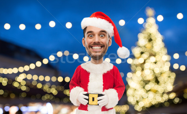 man in santa claus costume over christmas lights Stock photo © dolgachov