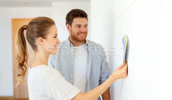 happy couple with color samples at new home Stock photo © dolgachov