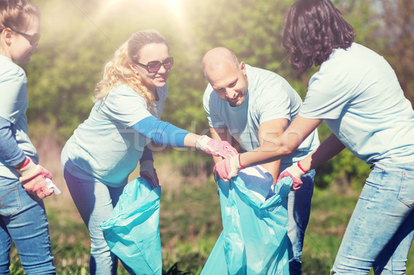 volunteers with garbage bags cleaning park area Stock photo © dolgachov