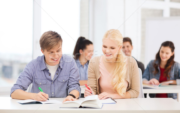 two teenagers with notebooks and book at school Stock photo © dolgachov