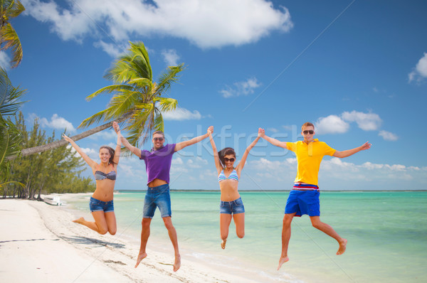 Grupo amigos casais saltando praia verão Foto stock © dolgachov