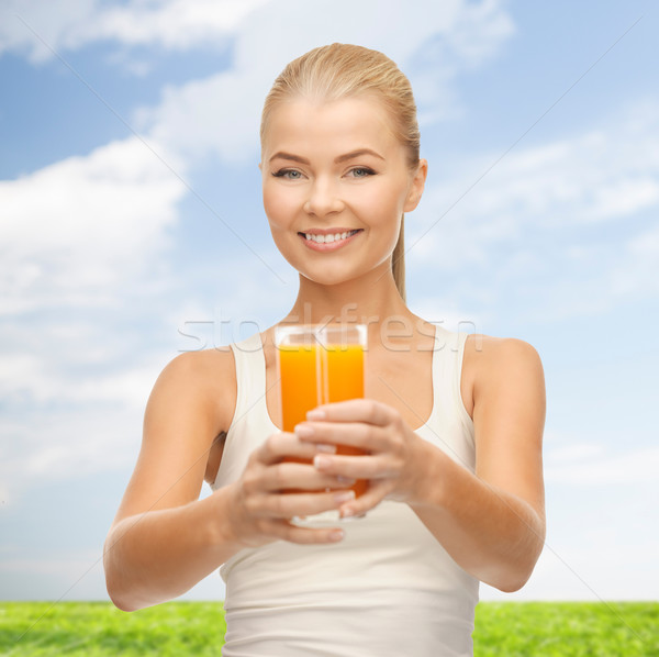 Stock photo: smiling woman holding glass of orange juice