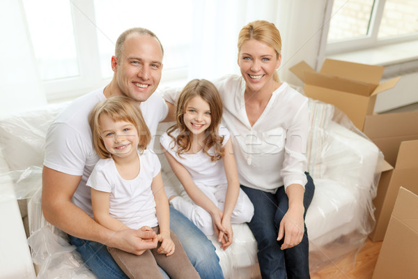 smiling parents and two little girls at new home Stock photo © dolgachov