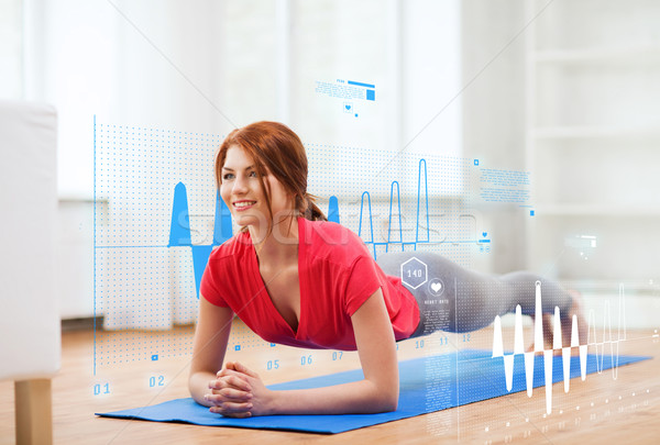 smiling redhead teenage girl doing plank at home Stock photo © dolgachov