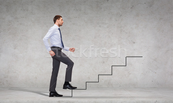 serious businessman stepping on step Stock photo © dolgachov