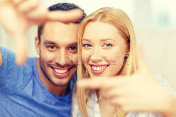 smiling happy couple making frame gesture at home Stock photo © dolgachov