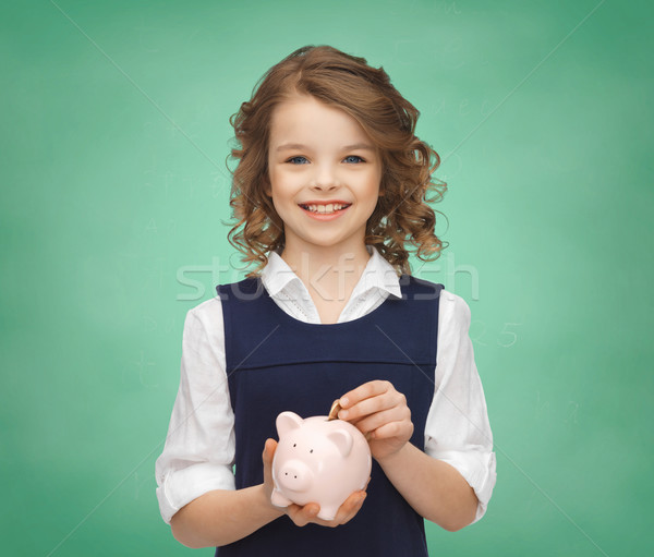 smiling girl putting coin into piggy bank Stock photo © dolgachov