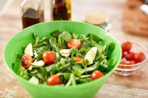 close up of salad bowl and spices on kitchen table Stock photo © dolgachov