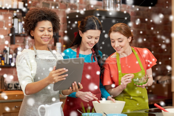 happy women with tablet pc cooking in kitchen Stock photo © dolgachov