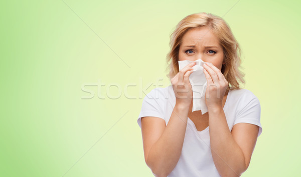 unhappy woman with paper napkin blowing nose Stock photo © dolgachov