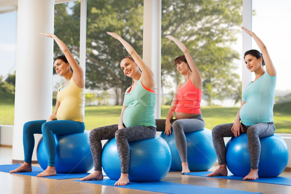 happy pregnant women exercising on fitball in gym Stock photo © dolgachov