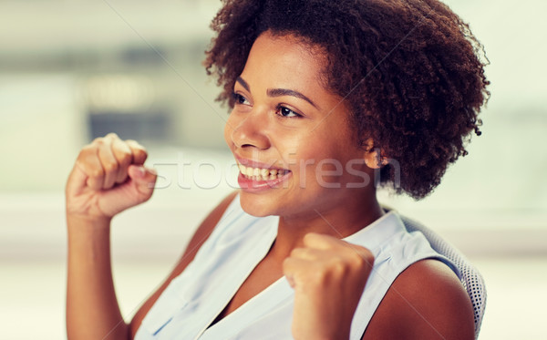happy african young woman with raised fists Stock photo © dolgachov