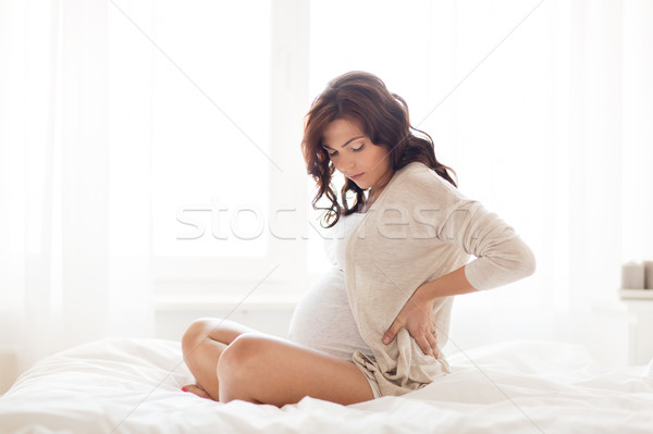 Kobieta w ciąży ból w krzyżu bed domu ciąży zdrowia Zdjęcia stock © dolgachov
