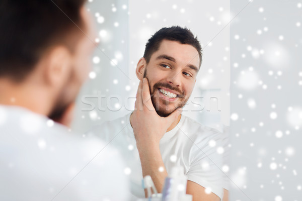 happy young man looking to mirror at home bathroom Stock photo © dolgachov