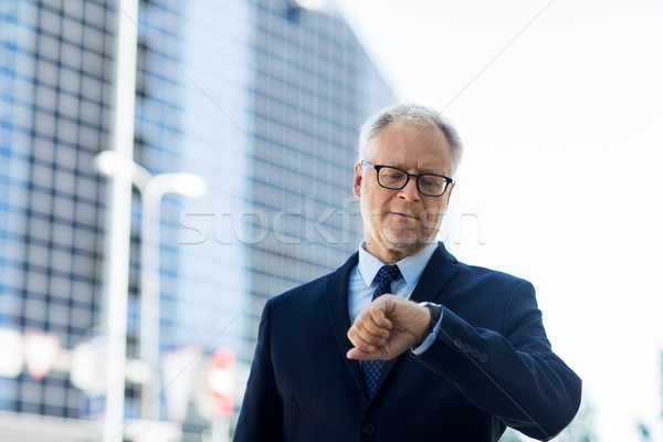 senior businessman checking time on his wristwatch Stock photo © dolgachov