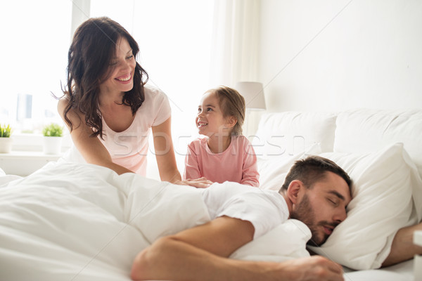 happy family waking up in bed at home Stock photo © dolgachov