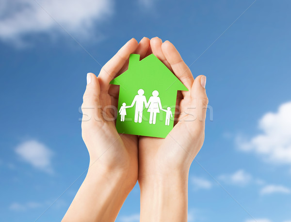 hands holding green house with family pictogram Stock photo © dolgachov