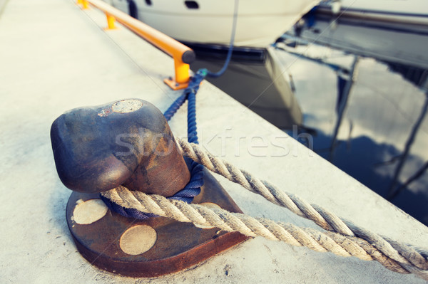 rusted iron mooring bollard with rope on pier Stock photo © dolgachov