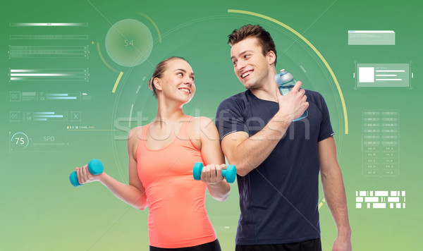 sportive man and woman with dumbbells and water Stock photo © dolgachov