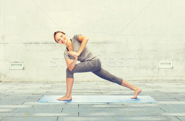 woman making yoga low angle lunge pose on mat Stock photo © dolgachov