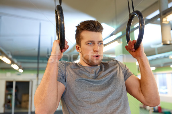 man exercising and doing ring pull-ups in gym Stock photo © dolgachov