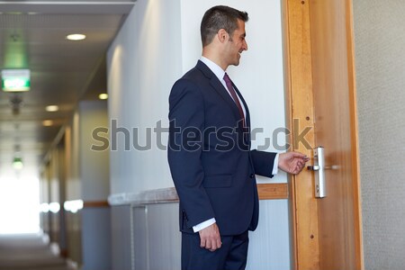 businessman with keycard at hotel or office door Stock photo © dolgachov