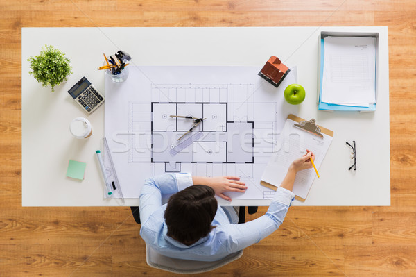 architect with blueprint writing to clipboard Stock photo © dolgachov