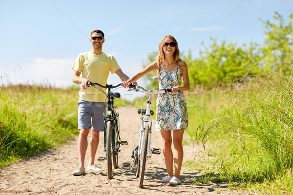 happy couple with bicycles on country road Stock photo © dolgachov