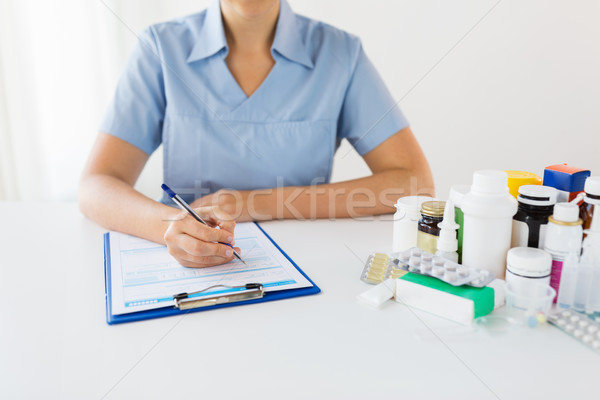 doctor with medicines and clipboard at hospital Stock photo © dolgachov