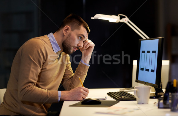man with notepad working at night office Stock photo © dolgachov