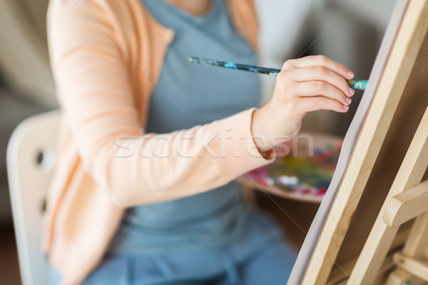 artist with brush painting at art studio Stock photo © dolgachov