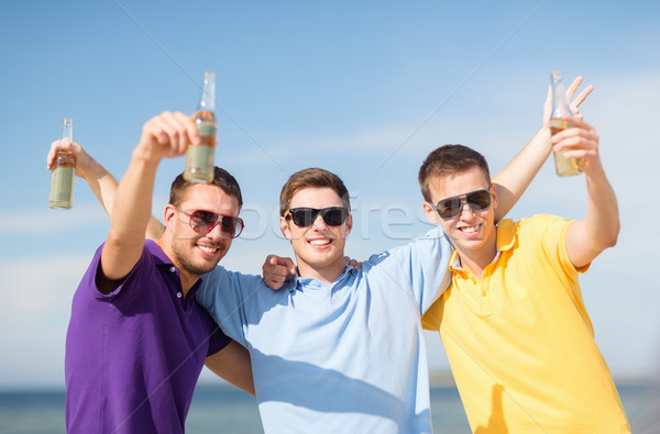 Vrienden strand flessen drinken zomer vakantie Stockfoto © dolgachov