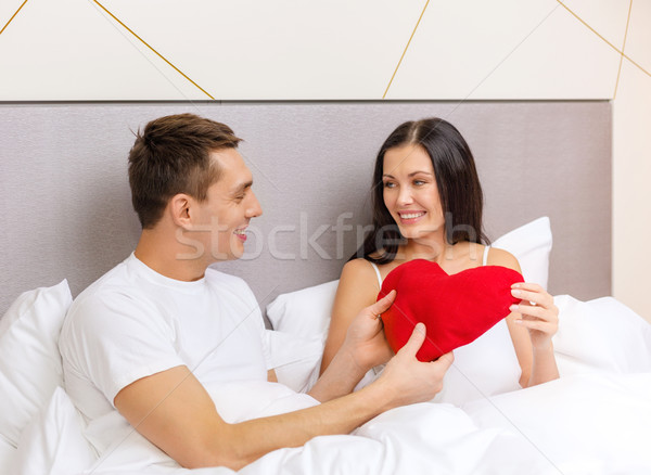 Gülen çift yatak kırmızı kalp şekli yastık Stok fotoğraf © dolgachov