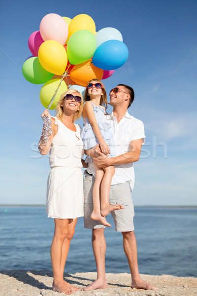 happy family with colorful balloons at seaside Stock photo © dolgachov