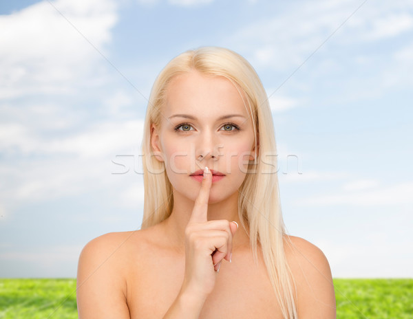 calm young woman with finger on lips Stock photo © dolgachov