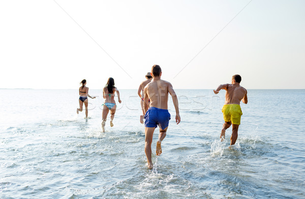 Foto stock: Sorridente · amigos · corrida · praia · de · volta · amizade