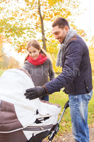 smiling couple with baby pram in autumn park Stock photo © dolgachov