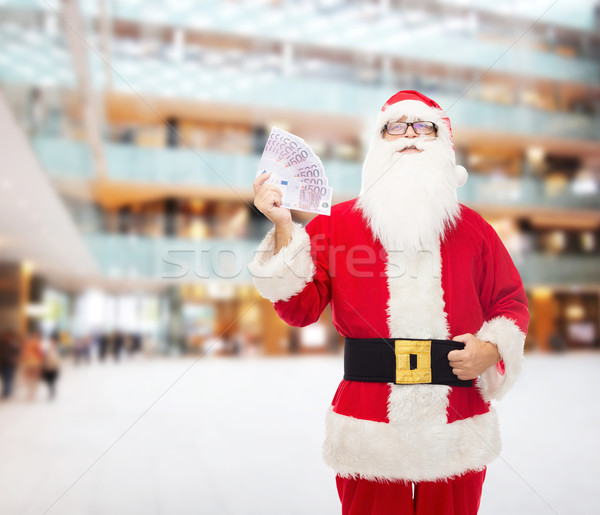 man in costume of santa claus with euro money Stock photo © dolgachov