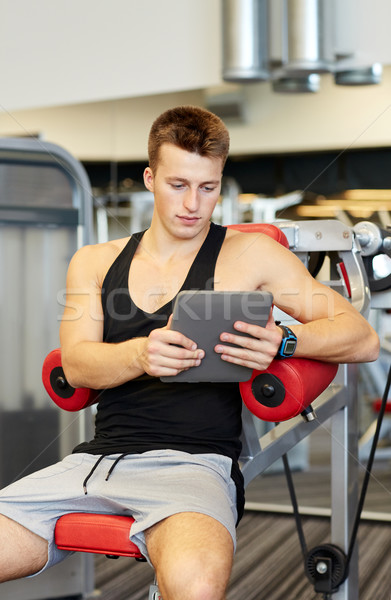 young man with tablet pc computer in gym Stock photo © dolgachov