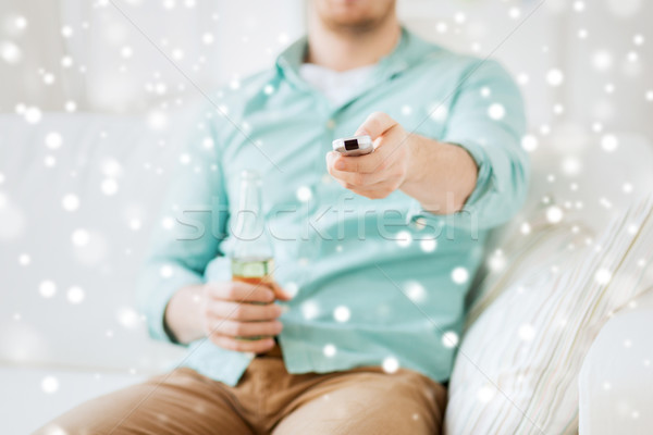 man with beer and remote control at home Stock photo © dolgachov