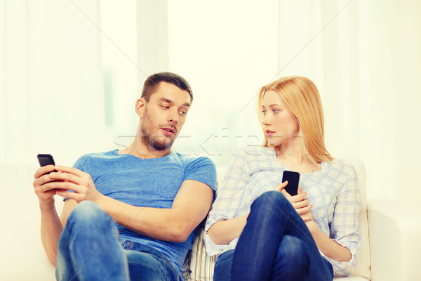 concentrated couple with smartphones at home Stock photo © dolgachov